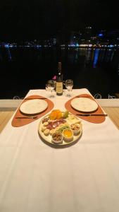 een tafel met een bord eten en een fles wijn bij Hotel Kuč in Budva