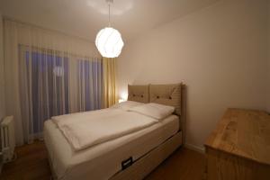 a bedroom with a bed and a chandelier at Apartament przy plaży 3 in Mielno