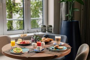 a table with breakfast foods and drinks on it at NH Berlin Kurf&uuml;rstendamm in Berlin