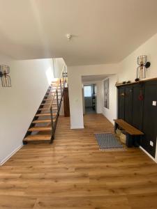 un pasillo con suelo de madera y escaleras en una casa en MAJA Der SpreeGarten en Cottbus