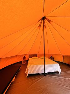 a bed in a large orange tent at Parque da Mina in Monchique