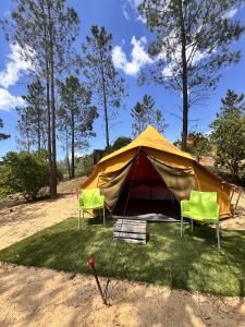 una tenda con due sedie e un pipistrello nell'erba di Parque da Mina a Monchique