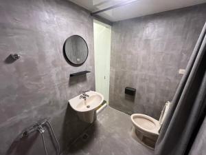 a bathroom with a sink and a toilet and a mirror at Nobiggie lnn in Kaohsiung