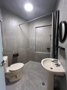 a bathroom with a toilet and a sink at Nobiggie lnn in Kaohsiung +3 photos