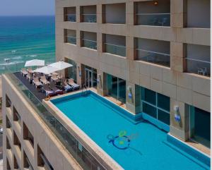 an overhead view of a hotel with a swimming pool and the ocean at GO to apartments in Leonardo in Bat Yam