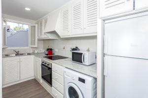 een keuken met witte kasten en een magnetron bij Apartamento con vistas en son Parc in Son Parc