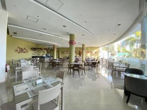 uma sala de jantar com mesas e cadeiras num restaurante em Winrich Hotel em Lapu Lapu City