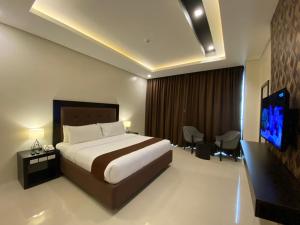 a hotel room with a bed and a flat screen tv at Winrich Hotel in Lapu Lapu City