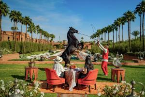 a group of people sitting at a table with a horse statue at Selman Marrakech in Marrakesh