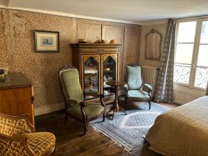 um quarto com uma cama, uma mesa e cadeiras em Epicerie Vieille du Puy en Velay em Le Puy en Velay