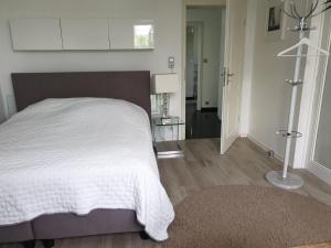 ein Schlafzimmer mit einem großen weißen Bett und einem Flur in der Unterkunft Apartment im Grünen zwischen Messe & Flughafen Köln! in Köln