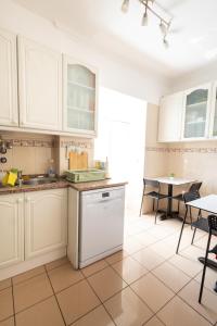 una cucina con armadietti bianchi e lavastoviglie di Sweet Suites Guesthouse close to famous Avenue Liberty a Lisbona