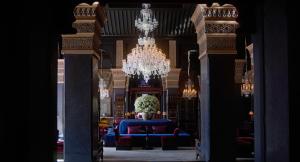 Habitación grande con sofá azul y lámpara de araña. en Selman Marrakech en Marrakech