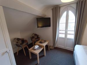 Habitación con 1 cama, 2 sillas y TV. en Chambres d'Hôtes La petite Salamandre, en Étretat