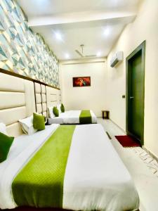 a large bed in a room with two beds at Hotel Olive Smart Stay in Agra