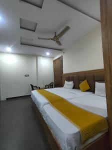 a bedroom with a large bed with a yellow blanket at Hotel Olive Smart Stay in Agra
