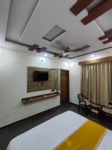 a living room with a flat screen tv and a couch at Hotel Olive Smart Stay in Agra