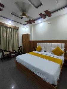 a bedroom with a large bed with yellow pillows at Hotel Olive Smart Stay in Agra
