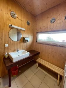 La salle de bains est pourvue d'un lavabo, d'une fenêtre et d'un banc. dans l'établissement Lõunaranna Harbour Accommodation, à Simisti