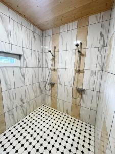 a bathroom with a shower with a tiled wall at Lõunaranna Harbour Accommodation in Simisti