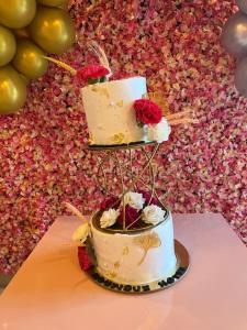 a three tiered cake with flowers on top of it at Shomaan boutique hotel in Sundarnagar