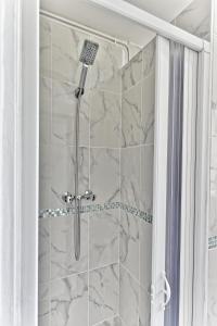y baño con ducha y paredes de mármol. en Appartement proche de Paris - Gagny, en Gagny