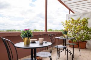 due tavoli e sedie su un balcone con piante di Vista Sulle Colline a Forlì