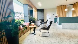 een lobby met stoelen en een tafel en een aantal planten bij Guest house Stara lipa Tašner - free parking & kitchenette in Maribor
