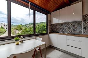 een keuken met een witte tafel en een aantal ramen bij Apartmani Kalos in Vela Luka
