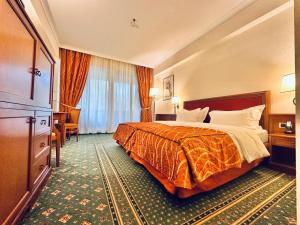 pokój hotelowy z łóżkiem i dużym oknem w obiekcie Lux Garden Hotel w mieście Azuga
