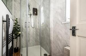 a shower with a glass door in a bathroom at The Boat House Sleeps 4 Pet Friendly in Dawlish