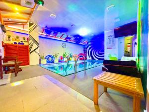 a room with a swimming pool with a bench in it at HS Miracle Grand in Hulhumale