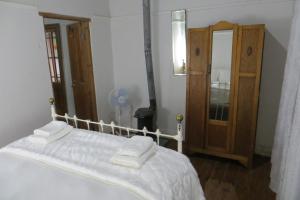 1 dormitorio con 1 cama y armario de madera en Oasis, en Nieu-Bethesda