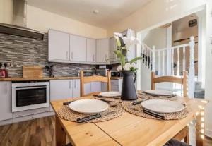 a kitchen with a wooden table with plates on it at The Boat House Sleeps 4 Pet Friendly in Dawlish