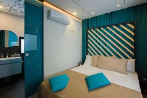 een slaapkamer met een bed met twee blauwe kussens erop bij Papillon Country Resort in Denekamp