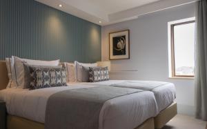 a bedroom with a large bed and a window at VIP Executive Suites do Marquês Hotel in Lisbon