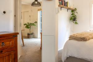 a bedroom with a bed and a wooden dresser at Jungle Cottage Escape in Auckland