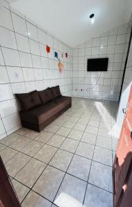 ein Wohnzimmer mit einem Sofa in einem gefliesten Zimmer in der Unterkunft Casa Mandacaru Espaço completo in Campina Grande