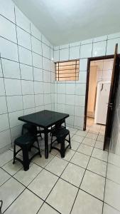 Zimmer mit einem Tisch, 2 Stühlen und einem Kühlschrank in der Unterkunft Casa Mandacaru Espaço completo in Campina Grande