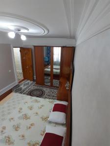 - un coin chambre avec un lit et un miroir dans l'établissement Dilshoda hi-tech, à Samarcande