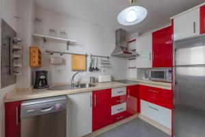 タリファにあるApartamento Ubicacion Perfectaのキッチン(赤いキャビネット、ステンレス製の冷蔵庫付)