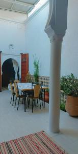 een eetkamer met een tafel en stoelen en een kolom bij Riad Diafa in Rabat
