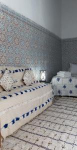 een slaapkamer met 2 bedden en een muur bij Riad Diafa in Rabat