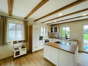 a kitchen with white cabinets and a wooden counter top at Die Scheune in Merkendorf
