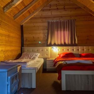 1 Schlafzimmer mit 2 Betten in einer Holzhütte in der Unterkunft Villat Gryka in Peja
