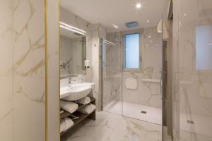 uma casa de banho com um lavatório e um chuveiro em Hotel Nasco em Milão