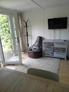 a living room with a sliding glass door and a tv at Private Self Contained Annex/Cabin in Birmingham