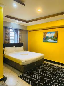 a bedroom with a bed with a yellow wall at Pendeza La Casa in Naivasha