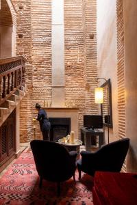 a man standing in a living room with a fireplace at La Villa Nomade in Marrakesh