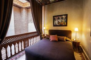 a bedroom with a bed and a balcony with a window at La Villa Nomade in Marrakesh